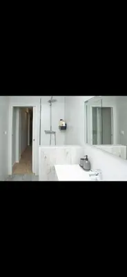 a white bathroom with a sink and a mirror at Habitación El Cabanyal in Valencia