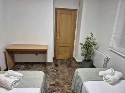 a room with two beds and a table and a door at PINEDO PLAYa in Valencia