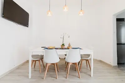 a white dining room table with four white chairs at Hogar con encanto a 10 min del centro de Valencia in Valencia