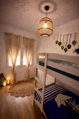 a bedroom with a bunk bed and a chandelier at Maison bord de plage avec patio extérieur aménagé in Puerto de Sagunto