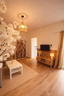 a living room with a television and a table at Maison bord de plage avec patio extérieur aménagé in Puerto de Sagunto