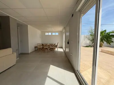 a living room with a table and chairs and a window at Villatella in Burriana
