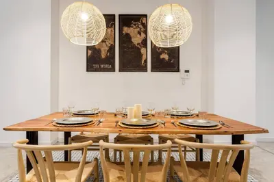 a dining room table with chairs and two lights at AIRE Holidays Valencia in Valencia