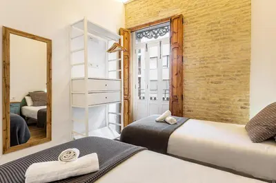 a bedroom with two beds and a mirror at AIRE Holidays Valencia in Valencia