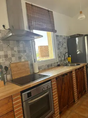a kitchen with a wooden table and white chairs at El mirador de Espadán in Segorbe
