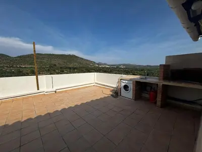 a kitchen and living room with a table and a couch at El mirador de Espadán in Segorbe