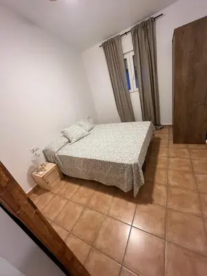 a bedroom with a bed and a tiled floor at El mirador de Espadán in Segorbe