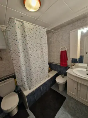a bathroom with a toilet sink and a shower curtain at Relax Zone Cullera Parking fee en edificio in Cullera