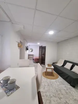 a white living room with a bed and a table at Rural studio in Cortez de Pallas