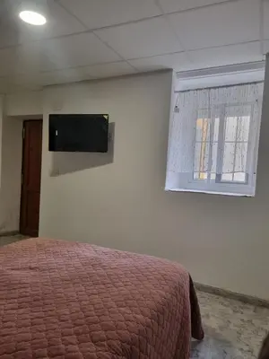 a bedroom with a bed and a television on the wall at Rural studio in Cortez de Pallas