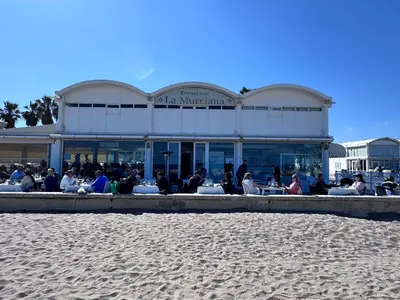 a group of people sitting outside of a building on the beach at Habitación privada con baño privado I in Valencia
