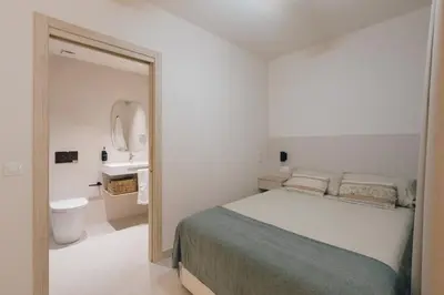 a white bedroom with a bed and a sink at GuestReady - Reental Apartments in Valencia