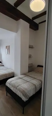 a bedroom with two beds and a ceiling with a light at Beachside apartment in Valencia