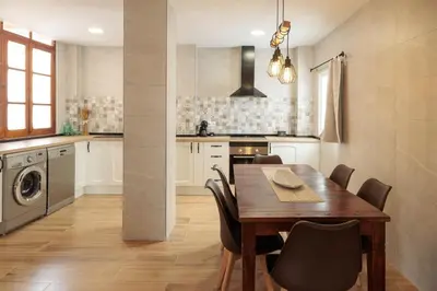 a kitchen with a wooden table and chairs in a room at Apartamento Estilo Rustico Buñol - ELPATIO- in Buñol