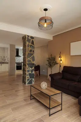 a living room with a couch and a stone pillar at Apartamento Estilo Rustico Buñol - ELPATIO- in Buñol