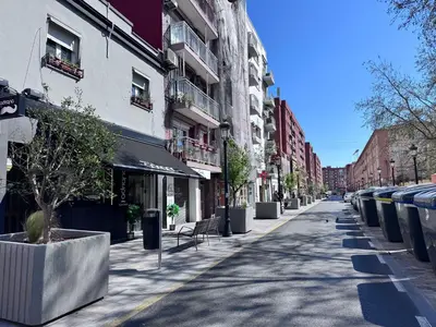 an empty city street with a row of trash cans at Habitacion privada con baño privado III in Valencia
