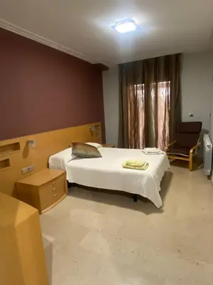 a bedroom with a bed and a chair and a window at Casa Flare Apartmento para 6 personas en Cheste in Cheste