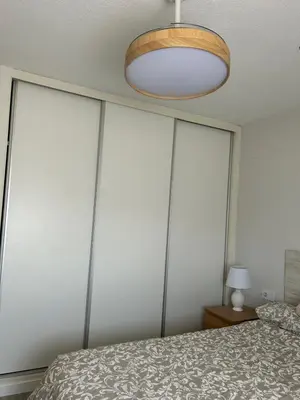 a bedroom with white walls with a bed and a lamp at District Key - Valencia, Manuel Candela in Valencia