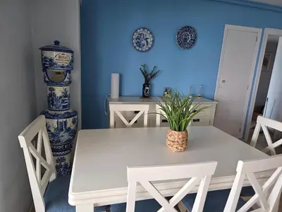 a dining room with a white table and chairs at Ca Ulises Frente al mar, pensado para desconectar in Valencia