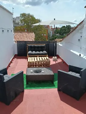 a patio with a couch and chairs on a roof at El Molino 2 Buñol Apartamento in Buñol