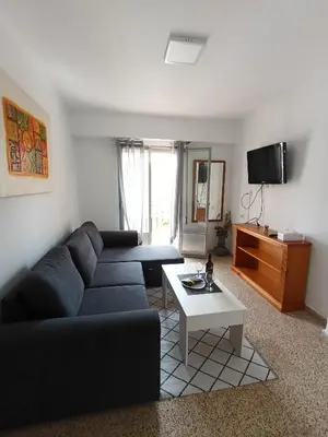 a living room with a black couch and a table at El Molino 2 Buñol Apartamento in Buñol