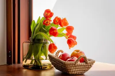 a vase with flowers and a basket of apples at Apartamento con patio playa cabanyal in Valencia
