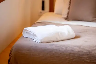 a white towel sitting on top of a bed at Apartamento con patio playa cabanyal in Valencia