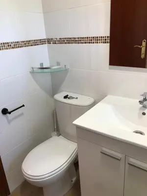 a white bathroom with a toilet and a sink at Torres del Saler, Gola de Puchol, Valencia in Valencia