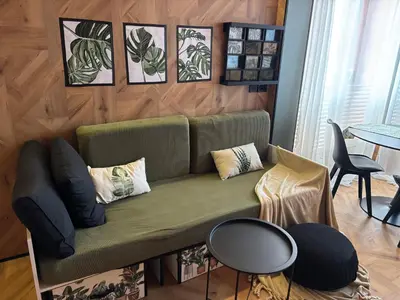 a living room with a green couch and a table at Farnals Playa Valencia in Masalfasar