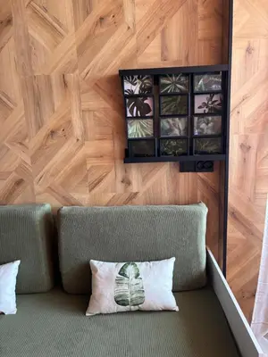 a couch in a room with a wooden wall at Farnals Playa Valencia in Masalfasar