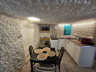 a kitchen with a table and chairs in a room at Bonita casa cueva con jacuzzi in Paterna