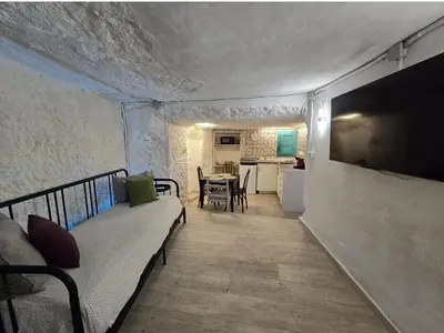 a living room with a couch and a television on a wall at Bonita casa cueva con jacuzzi in Paterna