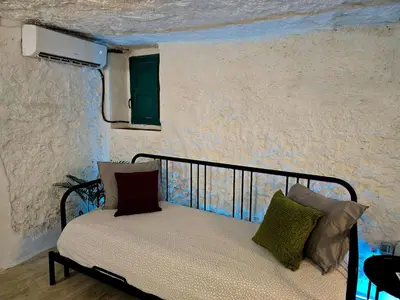 a bed with pillows on it in a room at Bonita casa cueva con jacuzzi in Paterna