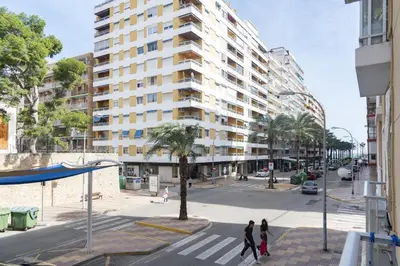 people crossing a street in front of a tall building at Pasaje Alzira 4B, 1-3 in Cullera