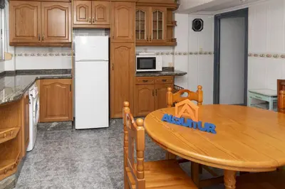 a kitchen with a wooden table and a white refrigerator at Pasaje Alzira 4B, 1-3 in Cullera