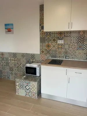 a kitchen with a counter with a microwave and tiles at Casa Perenchiza in Chiva