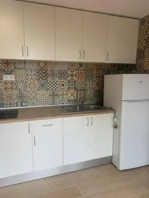a kitchen with white cabinets and a white refrigerator at Casa Perenchiza in Chiva