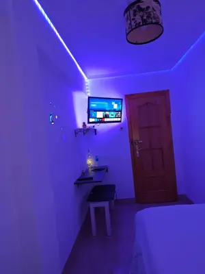 a purple room with a bed and a monitor on the wall at Habitación Manises Aeropuerto in Manises