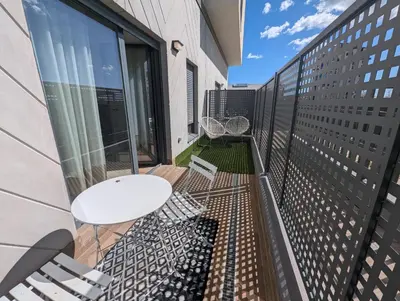 a balcony with a white table and chairs on a building at Port Suites Corporate Living Apartments in Valencia