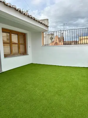 a balcony with green grass in a white house at Apartamento acogedor en el centro histórico de Sagunto in Sagunto