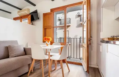a living room with a table and chairs and a couch at Apartamento acogedor en el centro histórico de Sagunto in Sagunto