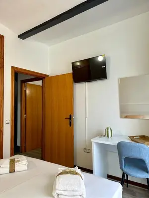 a room with a bed and a table and a door at Apartamento acogedor en el centro histórico de Sagunto in Sagunto