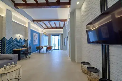 a living room with a couch and a tv on a wall at Invalencia - Alberic Waves L House in Valencia