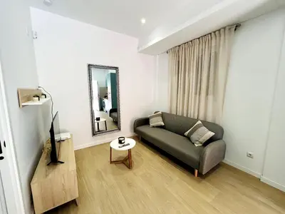 a living room with a couch and a mirror at Loft Sofia a estrenar con luz natural en corazon de Valencia in Valencia