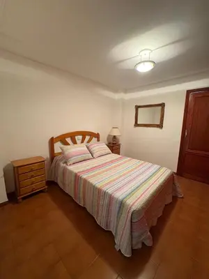 a bedroom with a bed with a striped bedspread at Apartamento Oasis in Cullera