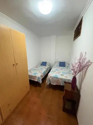 a room with two beds and a cabinet in it at Apartamento Oasis in Cullera