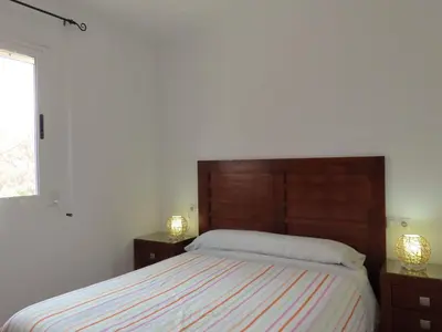 a bedroom with a bed with two night stands and two lamps at Casa del Prado in Navarrés