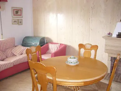 a living room with a table and chairs and a couch at Primer piso de 2 habitaciones en unifamiliar frente al mar in El Brosquil