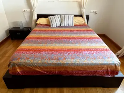 a bed with a colorful quilt on it in a room at Casa Mallaeta in Puebla de Vallbona
