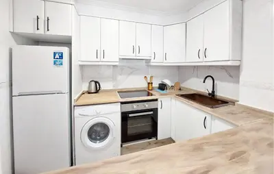 a kitchen with a white refrigerator and a dishwasher at Nice Apartment In Puebla De Farnals in Puebla de Farnals